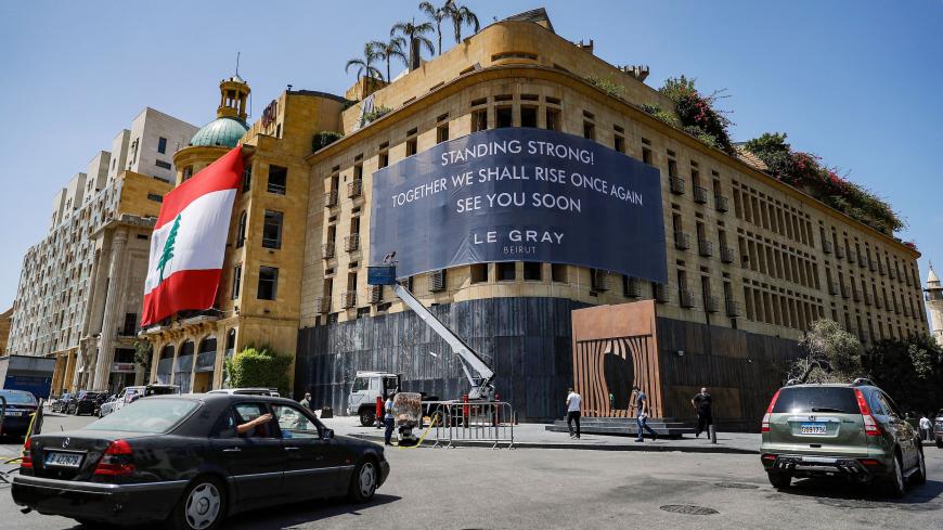 This picture taken on August 19, 2020 shows a view of the landmark Le Gray hotel in the centre of Lebanon's capital Beirut overlooking the Martyrs' Square, as a banner is hung across its facade reading in English "Stay strong! Together we shall riise once again, see you soon", and a giant Lebanese national flag hung over the facade of the neighbouring building, in the aftermath of the monster blast that ravaged the city earlier in August. (Photo by JOSEPH EID / AFP) (Photo by JOSEPH EID/AFP via Getty Images