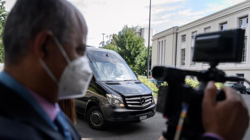A journalist wearing a protective face mask films the arrival of the bus carrying a delegation taking part in a meeting of Syria Constitutional Committee at the United Nations (UN) Office in Geneva on August 24, 2020. - Members of Syria's Constitutional Committee will be meeting for the first time since last November, following delays brought on by the coronavirus crisis. (Photo by Fabrice COFFRINI / AFP) (Photo by FABRICE COFFRINI/AFP via Getty Images)