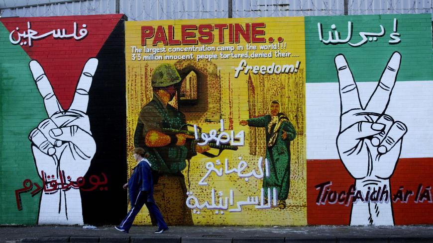 BELFAST, NORTHERN IRELAND - AUGUST 20:  An unidentified girl walks past a portion of a mural on Falls Road August 20, 2002 in west Belfast, Northern Ireland. The pro-Palestinian painting has appeared in several Nationalist areas across Belfast in recent weeks.  (Photo by Cathal McNaughton/Getty Images) 