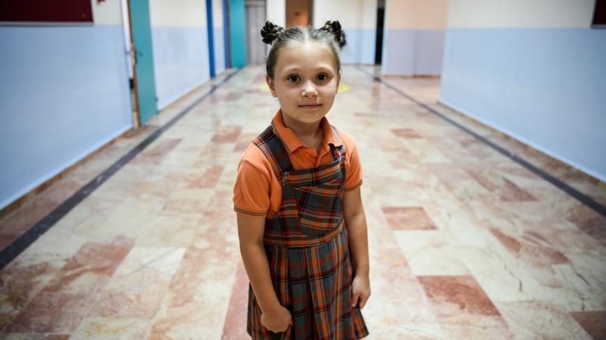 TOPSHOT - A school girl in her uniform stands in the corridor during the first day back at school on September 19, 2016 in Istanbul. - Turkish children returned to school for the first time since July's attempted coup -- but tens of thousands of their teachers have been sacked or suspended for suspected links to the putschists or to Kurdish rebels. (Photo by OZAN KOSE / AFP)        (Photo credit should read OZAN KOSE/AFP via Getty Images)