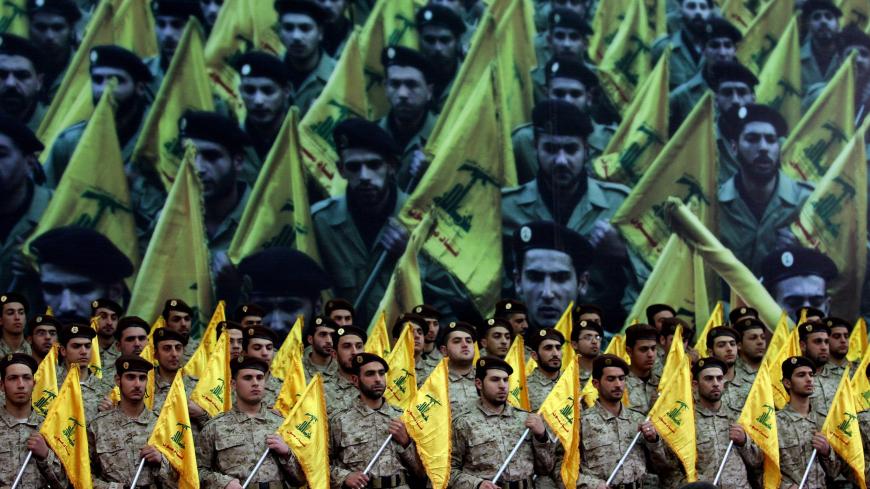 Shiite Muslims Hezbollah militants stand to attention as hundreds of people gather in a huge hall waiting to watch a televised speech by Hassan Nasrallah, the leader of the Shiite Muslim Lebanese Hezbollah militant group on February 22, 2008, in Beirut's southern suburb, ten days after the assassination of Hezbollah commander Imad Mughnieh in a bomb attack in Damascus. Nasrallah's televised speech marked the killing of Mughnieh and the 1992 assassination of its former leader Abbas Mussawi in an Israeli heli