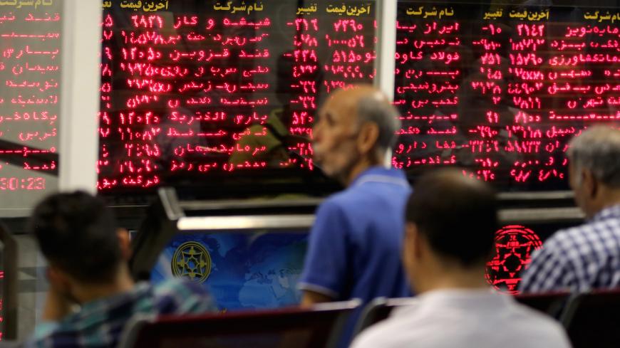 Iranian men monitor the stock market at Tehran Stock Exchange on July 1, 2019. - Iran's stock market is thriving, despite US sanctions which have battered its economy and an uncertain future as geopolitical tensions soar in the Gulf. Its main index, TEDPIX, has steadily risen over the last 12 months, accelerating in the most recent quarter to hit a historic high of 248,577 last week -- more than twice its level a year ago. (Photo by ATTA KENARE / AFP) (Photo credit should read ATTA KENARE/AFP via Get