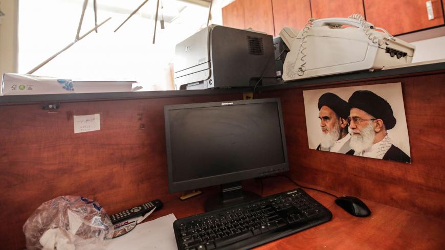 This picture taken on August 25, 2019 shows damage inside a media centre of the Lebanese Shiite group Hezbollah in the south of the capital Beirut, after two drones came down in the vicinity of its building earlier in the day, with (L to R) pictures of Iran's former and current Supreme Leaders, Ayatollah Ruhollah Khomeini and Ayatollah Ali Khamenei, seen next to a computer terminal. - Hezbollah said on August 25 that one of the drones was rigged with explosives and caused damage to its media centre, but den