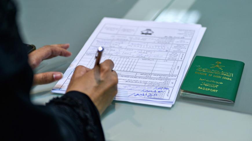A Saudi woman fills a passport renewal application at the Immigration and Passports Centre in the capital Riyadh on August 29, 2019. - Saudi Arabia has eased travel restrictions on women, allowing those aged over 21 to obtain passports without seeking the approval of their "guardians" - fathers, husbands or other male relatives, but observers say loopholes still allow male relatives to curtail their movements and, in the worst cases, leave them marooned in prison-like shelters. (Photo by FAYEZ NURELDINE / A