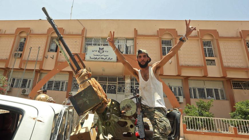 A fighter loyal to Libya's UN-recognised Government of National Accord (GNA) poses for a picture while seated in the turret a technical (pickup truck mounted with turret) in the town of Tarhuna, about 65 kilometres southeast of the capital Tripoli on June 5, 2020, after the area was taken over by pro-GNA forces from rival forces loyal to strongman Khalifa Haftar. - The GNA said on June 5 that it was back in full control of Tarhouna, the last stronghold of the forces of eastern strongman Khalifa Haftar. The 