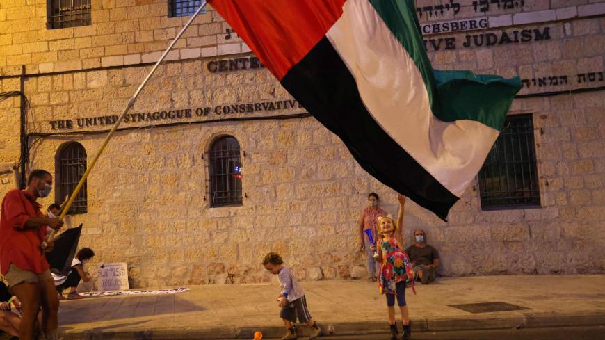 Israeli children play with the flag of the United Arab Emirates during an anti-government rally in front of the Prime Minister's residence in Jerusalem, on August 29, 2020. (Photo by EMMANUEL DUNAND / AFP) (Photo by EMMANUEL DUNAND/AFP via Getty Images)