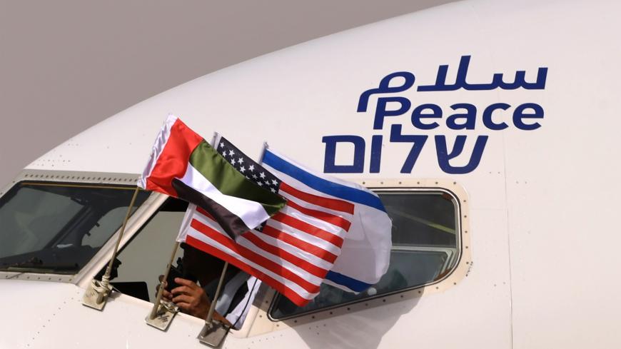 TOPSHOT - The Emirati, Israeli and US flags are picture attached to an air-plane of Israel's El Al, adorned with the word "peace" in Arabic, English and Hebrew, upon it's arrival at the Abu Dhabi airport in the first-ever commercial flight from Israel to the UAE, on August 31, 2020. - A US-Israeli delegation including White House advisor Jared Kushner took off on a historic first direct commercial flight from Tel Aviv to Abu Dhabi to mark the normalisation of ties between the Jewish state and the UAE. (Phot