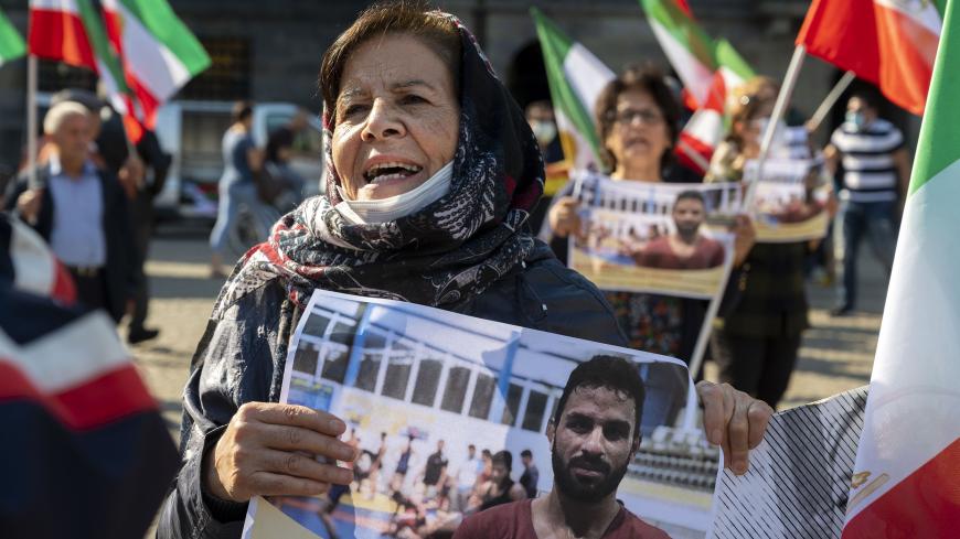 A woman holds a portrait of Iranian wrestler Navid Afkari during a demonstration on the Dam Square in Amsterdam, the Netherlands, on September 13, 2020, against its execution in the southern Iranian city of Shiraz and against the Iranian government. - Iran said it executed wrestler Navid Afkari, 27, on September 12, 2020 at a prison in the southern city of Shiraz over the murder of a public sector worker during anti-government protests in August 2018. Reports published abroad say Afkari was condemned on the