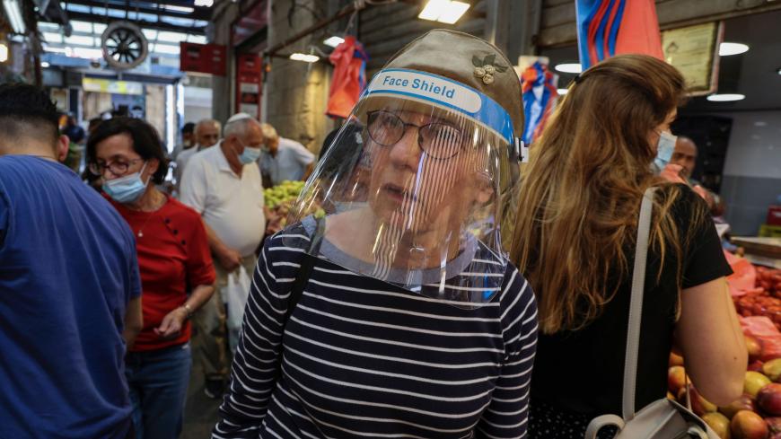 Shoppers wearing protective masks amid the COVID-19 pandemic, buy fresh produce at the Mahane Yehuda market in Jerusalem on September 14, 2020. - Israelis reacted with anger and dismay at an imminent nationwide lockdown aimed at curbing one of the world's highest novel coronavirus infection rates. (Photo by MENAHEM KAHANA / AFP) (Photo by MENAHEM KAHANA/AFP via Getty Images)