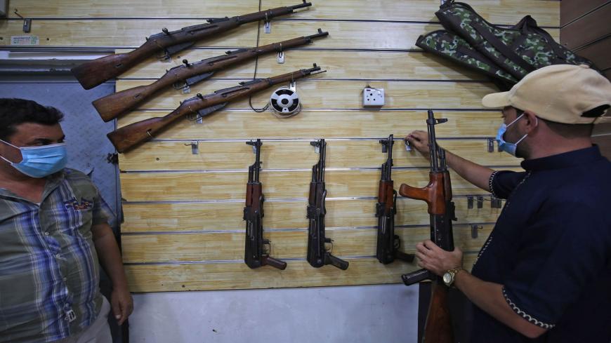 Employees display rifles for sale at a gun shop in the Iraqi capital Baghdad on September 22, 2020. (Photo by AHMAD AL-RUBAYE / AFP) (Photo by AHMAD AL-RUBAYE/AFP via Getty Images)