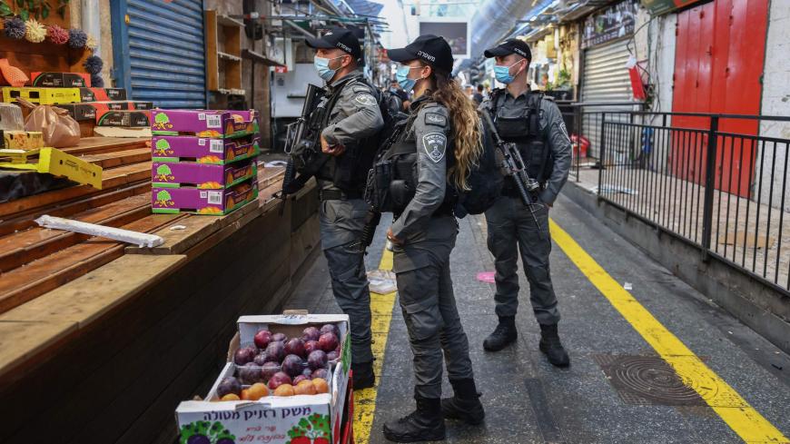 Israeli border policemen talk to a shopkeeper while on patrol in Jerusalem's main market during closure on September 25, 2020, as a series of measures to strengthen a second COVID-19 lockdown imposed last week takes effect. - The new measures, set to begin at 1100 GMT and affecting retails, workplaces, places of worship and demonstrations, were decided after Israel failed to bring down the world's highest coronavirus infection rate. (Photo by Emmanuel DUNAND / AFP) (Photo by EMMANUEL DUNAND/AFP via Getty Im