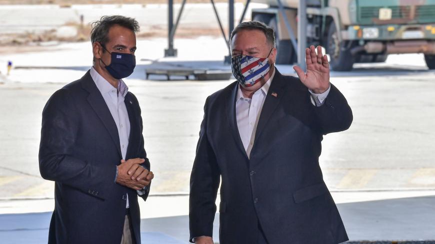 US Secretary of State Mike Pompeo (R) waves next to Greek Prime Minister Kyriakos Mitsotakis (L) during his visit to the Naval Support Activity base at Souda, the foremost US naval facility in the eastern Mediterranean on the Greek island of Crete. - US Secretary of State Mike Pompeo on September 29, 2020, concludes a two-day visit to Greece on with a tour of a strategically vital NATO base on a trip aimed at easing tensions between Greece and Turkey in the eastern Mediterranean. (Photo by ARIS MESSINIS / P