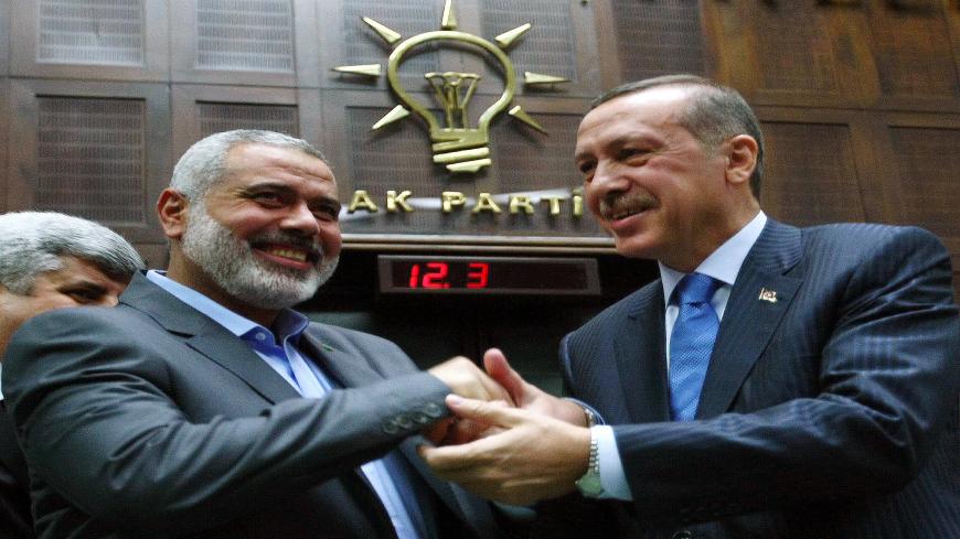 The Gaza Strip's Hamas Prime minister Ismail Haniyeh (L)  and his Turkish counterpart Recep Tayyip Erdogan shake hands in front of the lawmakers of Erdogan's Islamic-rooted Justice and Development Party at the Parliament in Ankara on  January 3, 2012.   Haniyeh's visit was a show of solidarity with the Islamic aid group IHH, which had planned to send the Mavi Marmara vessel with another Gaza flotilla last year but then dropped the plan. AFP PHOTO/ADEM ALTAN (Photo credit should read ADEM ALTAN/AFP via Getty