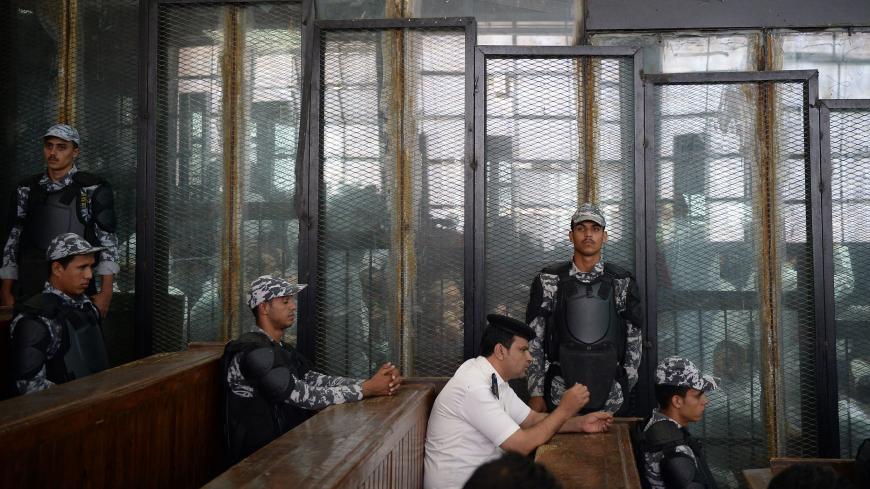 TOPSHOT - This picture shows the courtroom and soundproof glass dock (bottom) during the trial of 700 defendants including Egyptian photojournalist Mahmoud Abu Zeid, widely known as Shawkan, in the capital Cairo, on September 8, 2018. - Shawkan, who earlier this year received UNESCO's World Freedom Prize, was on September 8 handed a five-year jail sentence in a trial including over 700 other defendants over charges of killing police and vandalising property during the clashes, some of which were also handed
