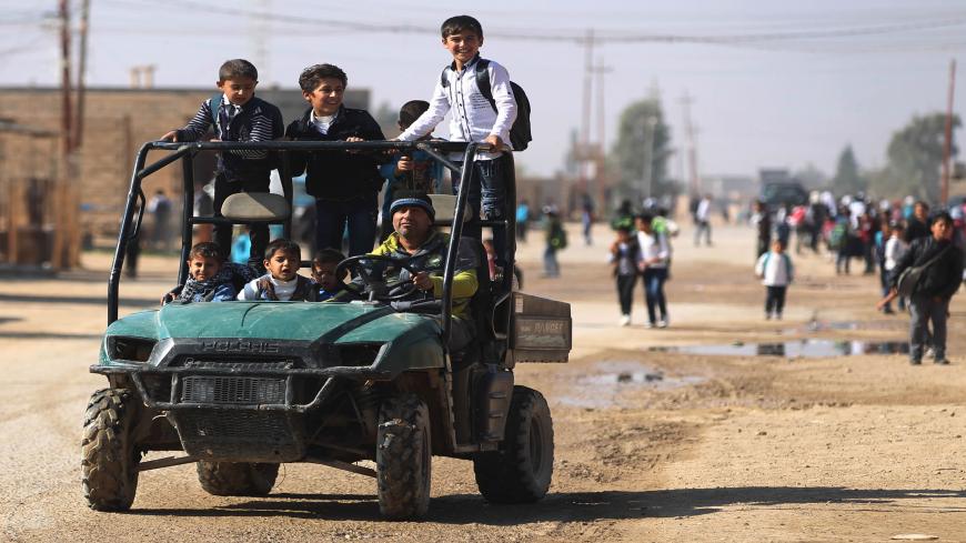 A man drives a group of pupils to school in al-Qaim in the Iraqi Anbar province, opposite Albu Kamal in Syria's Deir Ezzor region, on November 13, 2018. - Iraqi troops have reinforced their positions along the porous frontier with neighbouring war-torn Syria, fearing a spillover from clashes there between the Islamic State (IS) group and US-backed forces. (Photo by AHMAD AL-RUBAYE / AFP)        (Photo credit should read AHMAD AL-RUBAYE/AFP via Getty Images)