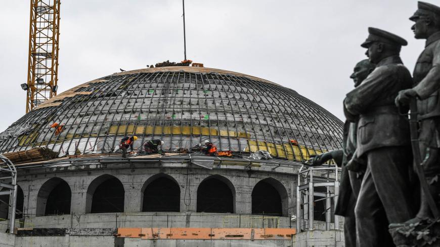 Construction labourers work on the top of a new mosque at Taksim square in Istanbul on January 14, 2019. (Photo by OZAN KOSE / AFP)        (Photo credit should read OZAN KOSE/AFP via Getty Images)