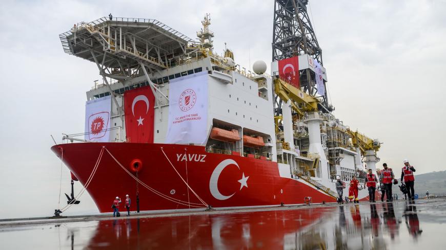 Journalists walk next to the drilling ship 'Yavuz' scheduled to search for oil and gas off Cyprus, at the port of Dilovasi, outside Istanbul, on June 20, 2019. - Turkey is set to send a new ship on June 20 to search for oil and gas off Cyprus, in a move expected to escalate tensions after the EU called on Ankara to stop its "illegal drilling activities". The region near the divided island is believed have rich natural gas deposits, triggering a race between Turkey and the internationally recognised Cyprus, 