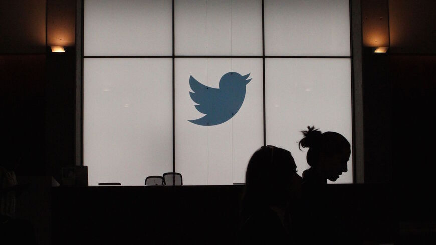 Employees walk past a lighted Twitter log as they leave the company's headquarters in San Francisco on August 13, 2019. - Twitter on August 13 said that by the end of the year users will be able to follow a small number of interests the same way they follow people. The feature will be rolled out internationally as the one-to-many messaging platform makes a priority of being an online venue for conversations rather than a pulpit for one-way broadcasting to the masses. (Photo by Glenn CHAPMAN / AFP) (Photo by