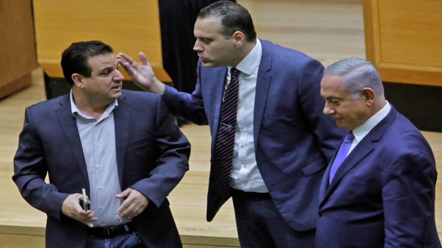 Israeli Knesset member (MK) Miki Zohar (C) intervenes between Israeli-Arab MK Ayman Odeh (L) and Prime Minister Benjamin Netanyahu (R) following an argument in the main Knesset chamber in Jerusalem on September 11, 2019. - A rare clash erupted between Netanyahu and Joint List Chairman Odeh on September 11 at the Knesset during a discussion ahead of a vote on a controversial, Likud party-sponspored bill to allow cameras in polling booths. (Photo by Gil COHEN-MAGEN / AFP)        (Photo credit should read GIL 