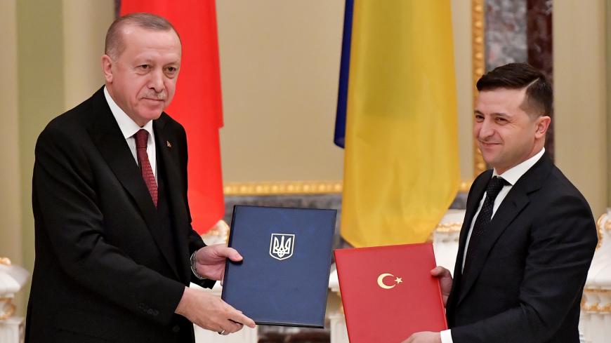 Ukrainian President Volodymyr Zelensky and his Turkish counterpart Recep Tayyip Erdogan exchange documents during a signing ceremony following their meeting in Kiev on February 3, 2020. (Photo by Sergei SUPINSKY / AFP) (Photo by SERGEI SUPINSKY/AFP via Getty Images)