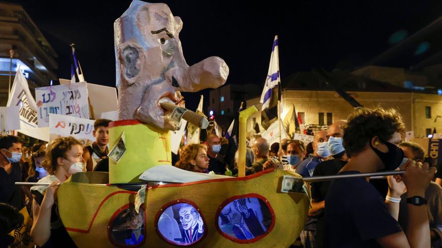 Israeli protesters lift a model of a yellow submarine topped with a representation of Prime Minister Benjamin Netanyahu during an anti-government demonstration in front of the Prime Minister's residence in Jerusalem, on August 15, 2020. (Photo by JACK GUEZ / AFP) (Photo by JACK GUEZ/AFP via Getty Images)