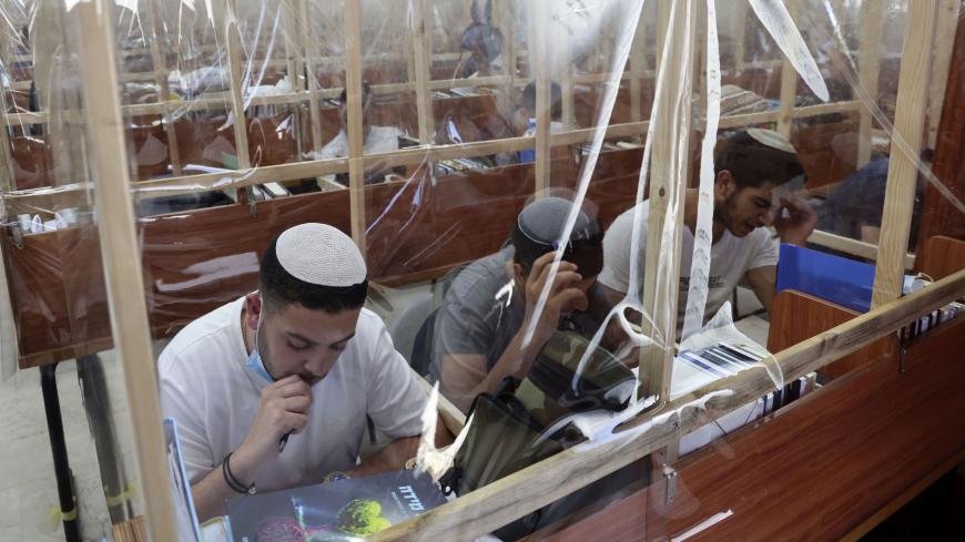 TOPSHOT - Orthodox Jewish yeshiva (religious school) students study separated by plastic cells set up amid the Covid-19 coronavirus pandemic, on August 25, 2020 in the southern Israeli city of Sdreot. - Israel has over 92,000 COVID-19 cases to its nine million population, with fewer than 700 deaths. (Photo by MENAHEM KAHANA / AFP) (Photo by MENAHEM KAHANA/AFP via Getty Images)