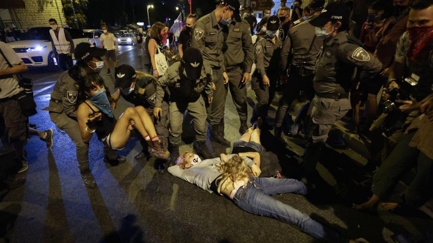 Police carry away a protester during an anti-government demonstration in front of the Prime Minister's residence in Jerusalem on August 29, 2020. - Protests demanding that Israeli Prime Minister Benjamin Netanyahu resign over several corruption indictments and his handling of the coronavirus crisis have been mounting in recent weeks, and the premier has been scathing in his counter-attack. (Photo by Emmanuel DUNAND / AFP) (Photo by EMMANUEL DUNAND/AFP via Getty Images)