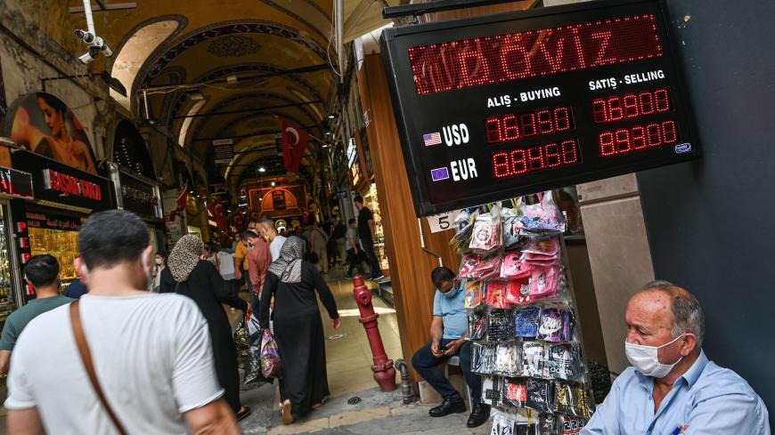 People walk past a screen showing rates at a currency exchange agency near Grand bazaar, in Istanbul, on September 24, 2020. - Turkey's central bank on September 24, 2020 raised its main interest for the first time since September 2018, boosting the rate by two percentage points to help the lira recover from historic lows. (Photo by Ozan KOSE / AFP) (Photo by OZAN KOSE/AFP via Getty Images)