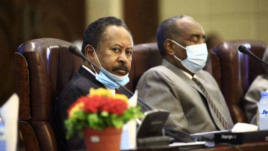 (L to R) Sudan's Prime Minister Abdalla Hamdok and the mask-clad (COVID-19 coronavirus pandemic precaution) Sovereign Council chief General Abdel Fattah al-Burhan attend the opening session of the First National Economic Conference in the capital Khartoum on September 26, 2020. (Photo by ASHRAF SHAZLY / AFP) (Photo by ASHRAF SHAZLY/AFP via Getty Images)