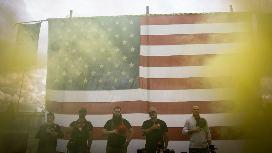 Yellow smoke fills the air as an American flag is raised at the start of a Proud Boys rally at Delta Park in Portland, Oregon on September 26, 2020. - Far-right group "Proud Boys" members gather in Portland to show support to US president Donald Trump and to condemn violence that have been occurring for more than three months during "Black Lives Matter" and "Antifa" protests. (Photo by Maranie R. STAAB / AFP) (Photo by MARANIE R. STAAB/AFP via Getty Images)