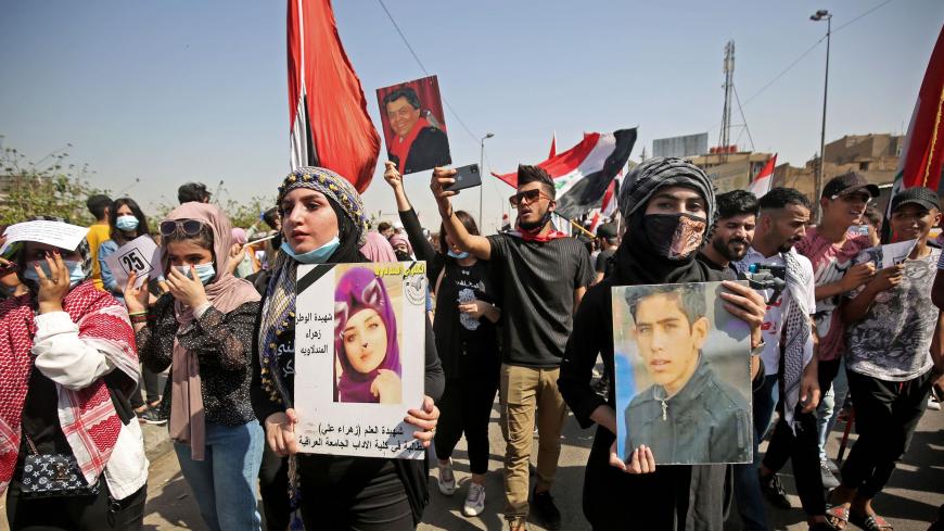 Iraqi demonstrators carry the portraits of slain protesters during a demonstration in Tahrir Square in the centre of Iraq's capital Baghdad on October 1, 2020, commemorating the first anniversary of the massive decentralised anti-government protest movement against unemployment, poor public services, and endemic corruption. - Back in October 2019, unprecedented protests demanded the fall of Iraq's ruling class. One year on, with a new government in place and nearly 600 protesters killed, almost nothing has 