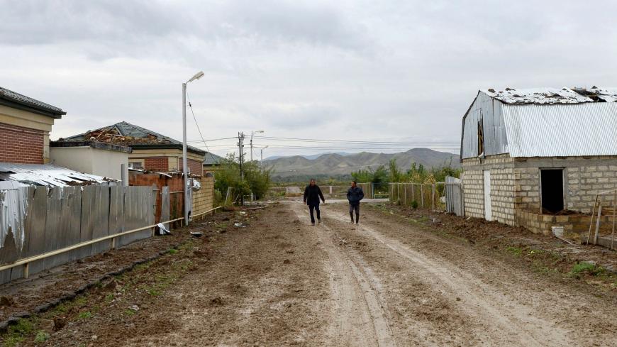 Men walk on a street of the village of Djojugh Marjanli in Azerbaijan's Jabrayil district which is said was damaged in shelling during the ongoing fighting between Armenia and Azerbaijan over the breakaway Nagorno-Karabakh region, October 6, 2020. (Photo by TOFIK BABAYEV / AFP) (Photo by TOFIK BABAYEV/AFP via Getty Images)