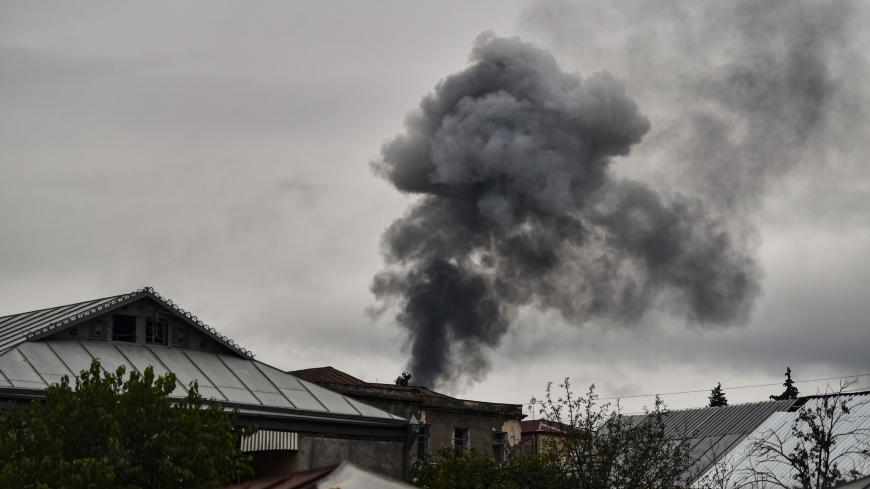 TOPSHOT - Smoke rises behind houses after shelling in the breakaway Nagorno-Karabakh region's main city of Stepanakert on October 7, 2020, during the ongoing fighting between Armenia and Azerbaijan over the disputed region. (Photo by ARIS MESSINIS / AFP) (Photo by ARIS MESSINIS/AFP via Getty Images)