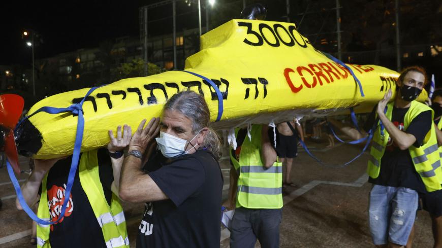 Israeli protesters, wearing protective masks due to the COVID-19 pandemic, carry a mock submarine during a demonstration against Prime Minister Benjamin Netanyahu in the coastal city of Tel Aviv, on October 17, 2020. (Photo by JACK GUEZ / AFP) (Photo by JACK GUEZ/AFP via Getty Images)