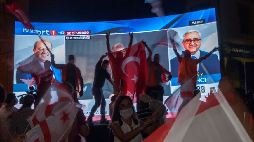 Supporters of right-wing nationalist Ersin Tatar celebrate his win in the presidential election in the northern part of Nicosia, the capital of the self-proclaimed Turkish Republic of Northern Cyprus (TRNC) on October 18, 2020. - Right-wing nationalist Ersin Tatar, backed by Ankara, scored a surprise victory in a run-off presidential election in breakaway northern Cyprus, ousting pro-reunification incumbent Mustafa Akinci. (Photo by Birol BEBEK / AFP) (Photo by BIROL BEBEK/AFP via Getty Images)