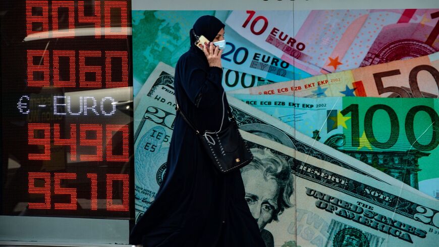 A woman walks past an information screen displaying rates in front of an exchange office in Istanbul, on October 26, 2020 as Turkey's lira set a new record low against the US dollar. - Turkey's lira was trading at 8.03 against the dollar at around 0730 GMT, suffering a loss of nearly one percent since the beginning of the day. The Turkish currency also recorded its lowest level against the euro, trading near 9.52. (Photo by Yasin AKGUL / AFP) (Photo by YASIN AKGUL/AFP via Getty Images)