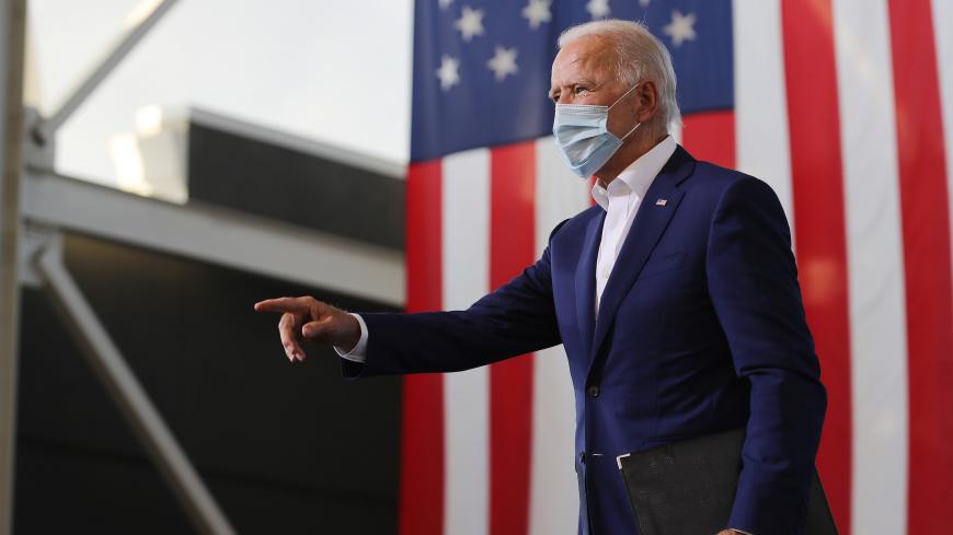 MIRAMAR, FLORIDA - OCTOBER 13: Wearing a face mask to reduce the risk posed by the coronavirus, Democratic presidential nominee Joe Biden points to supporters during a drive-in voter mobilization event at Miramar Regional Park October 13, 2020 in Miramar, Florida. With three weeks until Election Day, Biden is campaigning in Florida. (Photo by Chip Somodevilla/Getty Images)