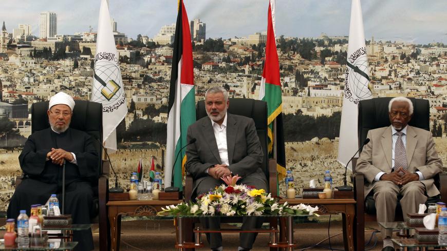 Hamas Prime Minister Ismail Haniyeh (C) meets with Egyptian Cleric and chairman of the International Union of Muslim Scholars Sheikh Yusuf al-Qaradawi (L) and former Sudanese president Abdel Rahman Swar Al Dahab (R) after their arrival in Gaza City on May 9, 2013. Al-Qaradawi arrived on May 8, 2013 for his first visit to Gaza Strip with a delegation of Muslim scholars. AFP PHOTO /MOHAMMED ABED        (Photo credit should read MOHAMMED ABED/AFP via Getty Images)