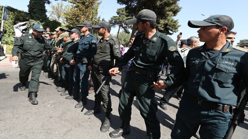 Iranian police stand between supporters of the Basiji militia and supporters of Iranian president Hassan Rouhani upon his arrival from New York, on September 28, 2013 in Tehran. Some 60 hardline Islamists chanted "Death to America" and "Death to Israel" but they were outnumbered by 200 to 300 supporters of the president who shouted: "Thank you Rouhani."   AFP PHOTO/ATTA KENARE        (Photo credit should read ATTA KENARE/AFP via Getty Images)