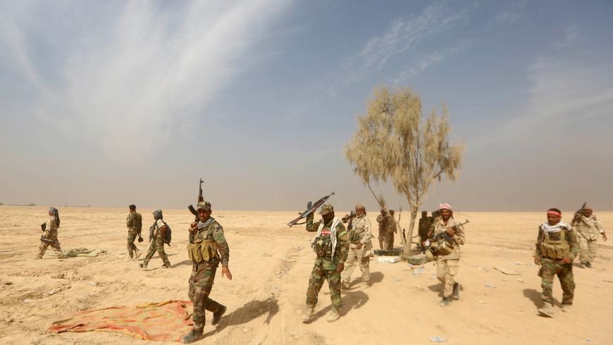 Iraqi Shiite fighters from the Popular Mobilisation units, fighting alongside Iraqi forces, head to the Makhoul mountains, north of Baiji, during a military operation against Islamic State (IS) group jihadists on October 17, 2015. After recapturing parts of Baiji and the huge nearby refinery complex from the Islamic State group, security and allied paramilitary forces thrust further northward up the main highway leading to Mosul. AFP PHOTO / AHMAD AL-RUBAYE / AFP / AHMAD AL-RUBAYE        (Photo credit shoul