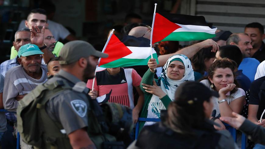 Palestinian demonstrators are separated by Israeli police barriers from Israelis celebrating Jerusalem Day, that marks the anniversary of the "reunification" of the holy city after Israel captured the Arab eastern sector from Jordan during the 1967 Six-Day War,  outside Damascus Gate in Jerusalem's old city on June 5, 2016. 

Israel occupied east Jerusalem in 1967 and later annexed it in a move never recognized by the international community. / AFP / AHMAD GHARABLI        (Photo credit should read AHMAD GHA