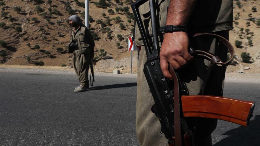 A member of the Kurdistan Workers' Party (PKK) carries an automatic rifle on a road in the Qandil Mountains, the PKK headquarters in northern Iraq, on June 22, 2018. - Hundreds of Iraqi Kurds marched Friday to protest Turkish strikes against the Kurdistan Workers' Party (PKK) after Turkey's President Recep Tayyip Erdogan said Ankara would press an operation against its bases. (Photo by SAFIN HAMED / AFP)        (Photo credit should read SAFIN HAMED/AFP via Getty Images)