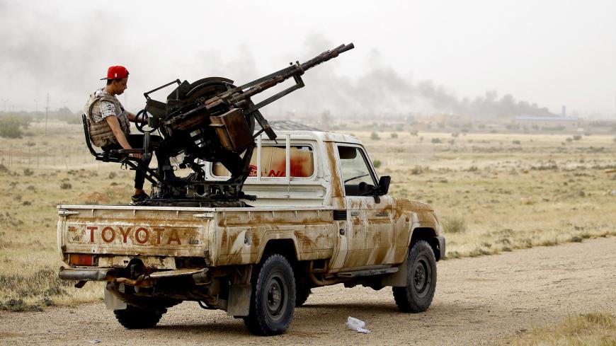 Vehicles belonging to Libyan fighters loyal to the Government of National Accord (GNA) are pictured during clashes with forces loyal to strongman Khalifa Haftar in al-Hira region 70 km south of the capital Tripoli, on April 23, 2019. - At least 264 people have been killed and over 1,200 wounded in weeks of fighting on the outskirts of Libya's capital, the World Health Organization said Tuesday, as African leaders gathered in Cairo to discuss the crisis. (Photo by Mahmud TURKIA / AFP)        (Photo credit sh
