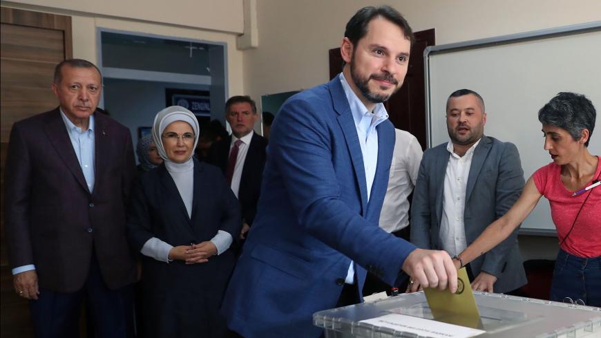 Turkish Finance Minister Berat Albayrak (C) casts his ballot at a polling station on June 23, 2019, during the mayoral election re-run in Istanbul, next to Turkish President Recep Tayyip Erdogan (rear L) and his wife Emine (rear 2nd L). - Istanbul went back to the polls on June 23, 2019 in a re-run of the mayoral election that has become a test of Turkish democracy as well as Turkish President's continued popularity at a time of economic trouble. (Photo by Adem ALTAN / AFP)        (Photo credit should read 