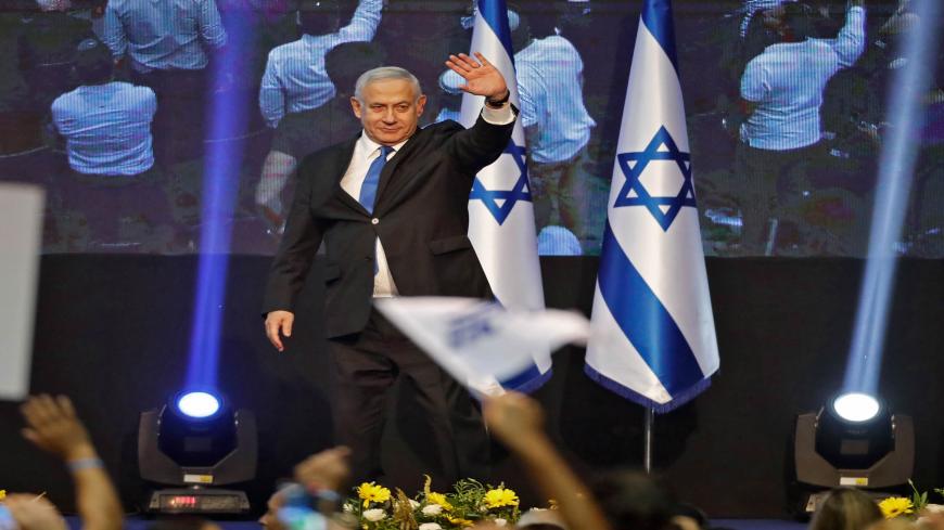 Israeli Prime Minister Benjamin Netanyahu waves to supporters upon arrival at his Likud party's electoral campaign headquarters to give an address early on September 18, 2019. - Israeli Prime Minister Benjamin Netanyahu said he was waiting for results in the country's general election, but that he was prepared for negotiations to form a "strong Zionist government." He spoke as exit polls showed a tight race between his right-wing Likud and ex-military chief Benny Gantz's centrist Blue and White alliance. (P