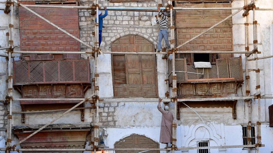 Construction workers stand on scaffolding in Al-Balad, a historical area in the Saudi Arabian port city of Jeddah, on January 11, 2020. (Photo by GIUSEPPE CACACE / AFP) (Photo by GIUSEPPE CACACE/AFP via Getty Images)