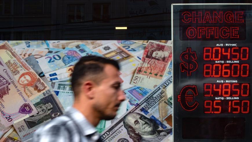 A man walks past an information screen displaying rates in front of an exchange office in Istanbul, on October 26, 2020 as Turkey's lira set a new record low against the US dollar. - Turkey's lira was trading at 8.03 against the dollar at around 0730 GMT, suffering a loss of nearly one percent since the beginning of the day. The Turkish currency also recorded its lowest level against the euro, trading near 9.52. (Photo by Yasin AKGUL / AFP) (Photo by YASIN AKGUL/AFP via Getty Images)
