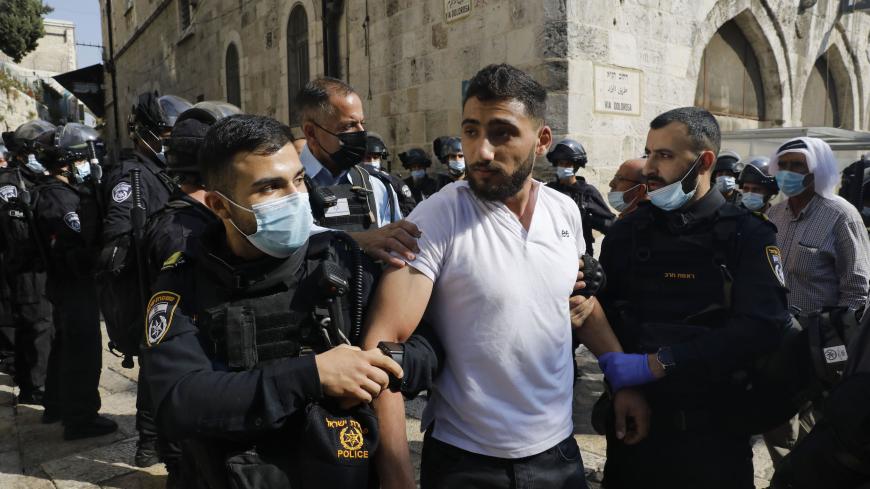 Israeli forces arrest a man following a protest against comments by French President Emmanuel Macron defending cartoons of the Prophet Mohammed, outside the al-Aqsa mosque compound, in the Old City of Jerusalem, on October 30, 2020. (Photo by Ahmad GHARABLI / AFP) (Photo by AHMAD GHARABLI/AFP via Getty Images)