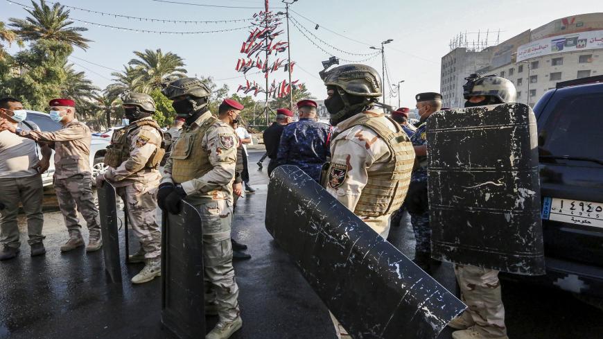 Members of the Iraqi security forces stand guard during the reopening of the Iraqi capital Baghdad's central Tahrir Square on October 31, 2020. - Iraqi authorities reopened Tahrir Square in central Baghdad, in a sign of easing tensions a year after the launch of an anti-government protest movement. Protests demanding a total overhaul of the ruling class lost momentum then ground to a halt in the spring due to the coronavirus crisis and rising US-Iran tensions. (Photo by Sabah ARAR / AFP) (Photo by SABAH ARA