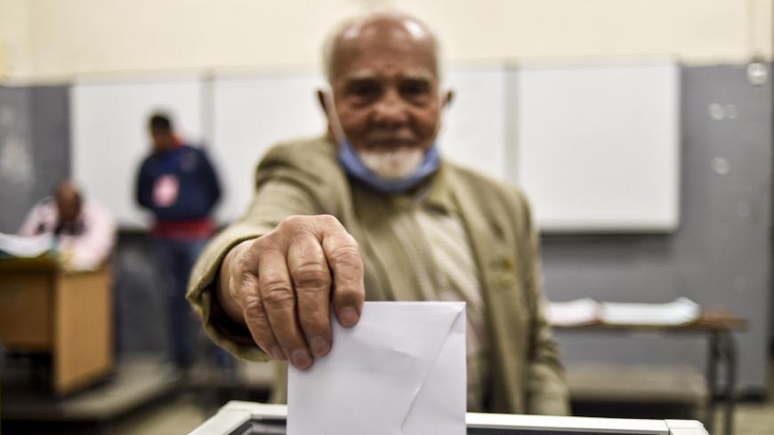 A man casts his vote just before polls close at a polling station in Algeria's capital Algiers on November 1, 2020, during a referendum on a revised constitution. - Algerians on November 1 largely snubbed a poll on a revised constitution the regime hoped would neutralise a protest movement which at its peak last year swept long-time president Abdelaziz Bouteflika from power. With the "yes" camp almost certain to win, the only real question mark was over participation in a vote also seen as a bid to bolster 